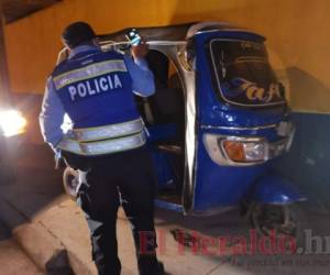 Un policía inspecciona la unidad de mototaxi que participó en el fatal accidente que segó la vida de la pequeña. Foto: Alex Pérez/EL HERALDO.