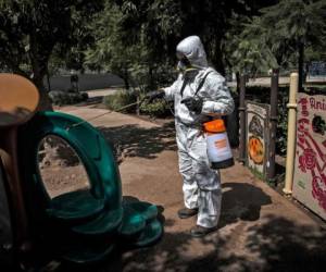 Un trabajador desinfecta los juegos infantiles como medida preventiva contra la propagación del nuevo coronavirus, COVID-19, en el parque Bicentenario, en Santiago. Foto: Agencia AFP.