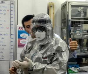 El viceministro de Salud de Vietnam, Nguyen Truong Son, se pone un traje de protección antes de ingresar a un área de aislamiento para visitar los dos primeros casos de la nueva infección por coronavirus, en el hospital Cho Ray en la ciudad de Ho Chi Minh el 23 de enero de 2020. FOTO: AFP