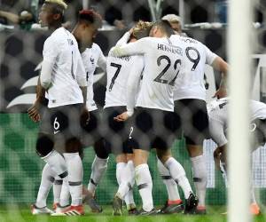 France's goalkeeper Hugo Lloris (C), flanked by France's forward Antoine Griezmann (L), France's defender Lucas Hernandez (2nd L) and France's defender Samuel Umtiti (R) holds the trophy as he celebrates with teammates while they disembark from the plane upon their arrival at the Roissy-Charles de Gaulle airport on the outskirts of Paris, on July 16, 2018 after winning the Russia 2018 World Cup final football match. / AFP PHOTO / Thomas SAMSON
