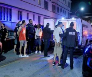 Policías de la Ciudad de Miami arrestan a varios hombre en la esquina de Ocean Drive y la Calle 10 durante el inicio oficial de las vacaciones de primavera, el sábado 20 de febrero de 2021, en Miami Beach, Florida. (Pedro Portal/Miami Herald via AP).