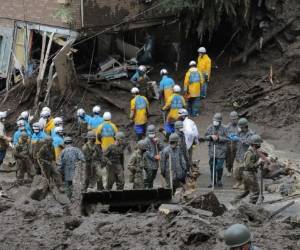 Miembros de las Autodefensas y policías buscan personas desaparecidas en el lugar de un deslizamiento de tierra luego de días de fuertes lluvias en Atami, en la prefectura de Shizuoka, el 5 de julio de 2021. Foto: AFP