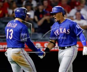 Ronald Guzmán (derecha) celebra un jonrón de dos carreras con su compañero de los Rangers de Texas Joey Gallo (13) en el segundo inning del juego de la MLB.