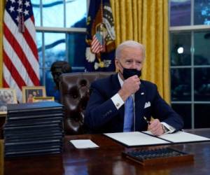 Momento en que el presidente Biden se aprestaba a firmar los primeros decretos. AFP.