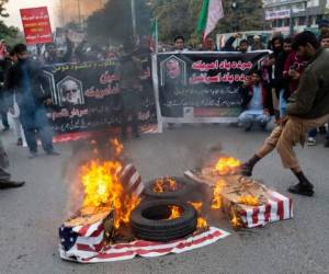 Unas personas quemaron banderas estadounidenses durante una protesta por el ataque de Estados Unidos que provocó la muerte del general iraní Qassem Soleimani, en Islamabad, Pakistán. (AP Foto/B.K. Bangash).