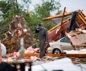 Thomas Glover busca una billetera en la casa dañada por la tormenta de su cuñada el 13 de abril de 2020 en Livingston, Carolina del Sur. Foto: Agencia AFP.