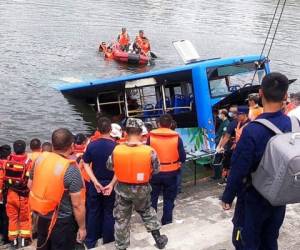 En esta fotografía proporcionada por la Agencia de Noticias Xinhua, se muestran unos socorristas que tratan de sacar un autobús que cayó en un lago en la ciudad de Anshun, en la provincia de Guizhou, en el suroeste de China. Foto: AP