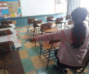 Una alumna del CEB República de Argentina señala la silla que usaba a diario Sailyn Gabriela Colindres Palma. Foto Estalin Irías| EL HERALDO