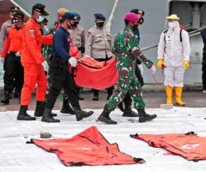 Rescatistas trasladan una bolsa con elementos recuperados tras el accidente de un avión de Sriwijaya Air, en el puerto de Tanjung Priok, Indonesia, el 12 de enero de 2021. Foto: AFP