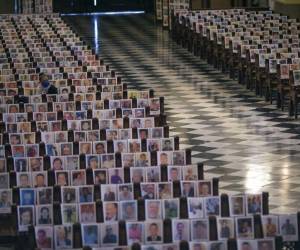 Una mujer se sienta entre miles de fotografías de personas que fallecieron a causa del COVID-19, en la Catedral de Lima, Perú. Foto AP