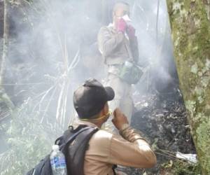 Miembros del Cuerpo de Bomberos en la zona de donde sale el humo está ubicado en la montaña 'Los Hornitos', a 12 kilómetros de Pico Bonito. Foto: EL HERALDO