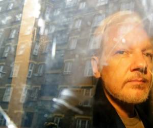 En esta imagen del 1 de mayo de 2019, las fachadas de los edificios se reflejan en una ventana mientras el fundador de WikiLeaks Julian Assange es retirado de una corte en Londres. Foto: AP.