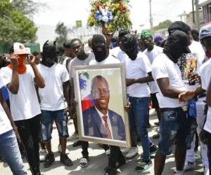 Miembros de una pandilla encabezada por Jimmy Cherizier, alias Barbecue, un expolicía que encabeza una coalición de pandillas llamada 'Familia G9 y Aliados', transportan un retrato del asesinado presidente Jovenel Moïse durante una marcha efectuada. Foto:AP