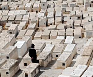 Un hombre ultra ortodoxo llora en las tumbas en el cementerio judío en el Monte de los Olivos frente a la Ciudad Vieja de Jerusalén. Foto: Agencia AFP.