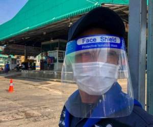 En esta foto del 20 de diciembre del 2020, un guardia con el rostro protegido y una máscara custodia el mercado de camarones en Samut Sakhon, al sur de Bangkok, Tailandia. El gobernador de la provincia en el centro de un creciente brote de coronavirus en Tailandia está infectado también, tras una reunión con funcionarios de salud pública en la que participó el viceprimer ministro. Foto: AP