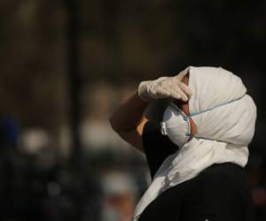 Una mujer protege completamente su rostro para evitar contagiarse de Covid-19. Foto AFP