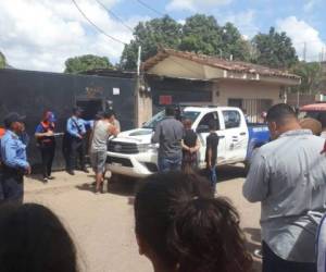 Elementos policiales, familiares y vecinos afuera de la cuartería donde este domingo se registró una masacre que dejó cinco muertos en Juticalpa, Olancho.