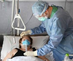El doctor Enrico Ramoni, con equipo de protección, comprueba el equipo médico de un paciente en la nueva unidad de cuidados intensivos de nivel COVID-3. Foto AFP