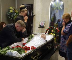 Elena German (de pie, a la izquierda), la pareja de Alexander Taraikovsky, quien murió durante una protesta contra los resultados oficiales electorales, y la familia de él lloran durante su funeral en Minsk, Bielorrusia. Foto AP
