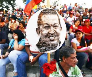Supporters of Venezuelan President Hugo Chavez attend an open-air mass in Caracas on February 22, 2013. Venezuela's cancer-stricken President Chavez is still suffering from respiratory problems, and the evolution of that condition 'has not been favorable,' the information minister said Thursday. The growing presence of Vice President Nicolas Maduro on state-run television, normally focused on ailing President Hugo Chavez, is giving analysts a sense that a transition is afoot in Venezuela. AFP PHOTO/Juan BARRETO