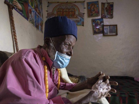 El centenario Tilahun Woldemichael llora y reza después de pasar semanas en un hospital recuperándose del coronavirus, en su casa en Adis Abeba, Etiopía. Foto: Agencia AP.