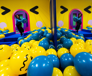 Detrás suyo está la “sala emoji”, repleta de bolas azules y amarillas representando las archiconocidas caras sonrientes.