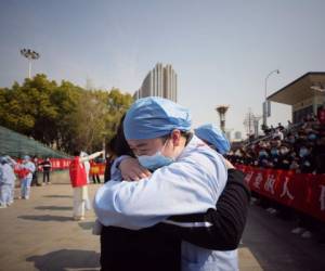 Un trabajador médico (R) abraza a un miembro de un equipo de asistencia médica de la provincia de Jiangsu en una ceremonia que marca su partida después de ayudar con el esfuerzo de recuperación del coronavirus Covid-19, en Wuhan. Foto: Agencia AFP.