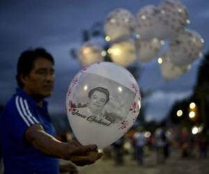 Personas sostiene globos con la cara del ídolo musical mexicano, mientras hacían su velatorio en Ciudad Juárez.