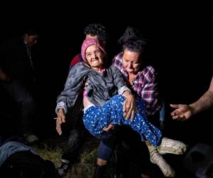 Trinidad Tabora, de 93 años, es llevada a la orilla estadounidense del Río Grande el 29 de abril de 2021 en Roma, Texas. Ella y su nieta fueron llevadas de contrabando a través de la frontera con otros solicitantes de asilo centroamericanos durante la madrugada. FOTOS: AFP
