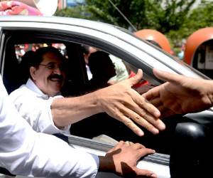 Former Honduran President Manuel Zelaya greets supporters, gathered under the Popular Resistance Broad Front (FARP), during a demonstration to commemorate the third anniversary of the coup d'etat that deposed him, in Tegucigalpa on June 28, 2012. AFP PHOTO/Rodrigo ARANGUA