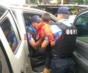 Momento en el que las autoridades tomaron en sus brazos al menor y arrestaron a la madre. (Foto: Estalin Irías / EL HERALDO)
