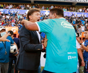 Un partidario de Querétaro (R) se enfrenta al entrenador en jefe argentino de Querétaro, Hernán Cristante (L) durante el partido de fútbol del torneo Clausura mexicano entre Querétaro y Atlas en el estadio Corregidora.