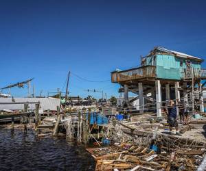 La gente limpia los escombros después del huracán Ian en Fort Myers Beach, Florida, el 30 de septiembre de 2022.