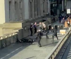 En esta captura tomada del video puesto a disposición por @HLOBlog, un hombre está rodeado por la policía después de un incidente en el Puente de Londres, en Londres, el viernes 29 de noviembre de 2019.
