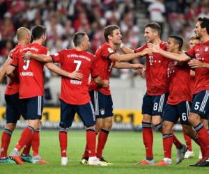 El delantero alemán del Bayern de Múnich Thomas Mueller es felicitado por sus compañeros de equipo después de anotar el 0-3 durante el partido de fútbol de la Bundesliga. Foto AFP.