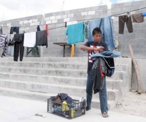 Brian, de 14 años, recoge ropa de un tendedero en el albergue para migrantes Senda de Vida en Reynosa, México. Partió solo desde Honduras y espera finalizar su travesía hacia Estados Unidos. (Fotos: AP)