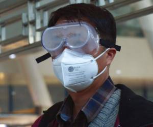 Un viajero porta una mascarilla y gafas protectoras mientras espera un tren para viajar a Beijing, en la ciudad de Wuhan. Foto: AP.