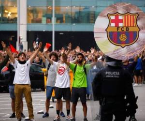 Policías antimotines vigilan las acciones de los manifestantes afuera del aeropuerto El Prat en Barcelona. Foto: AP.