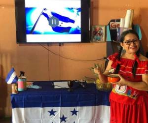 La profesora Gloria celebra el Día del Indio con un traje de danza y con fervor patrio tiene la bandera del país.