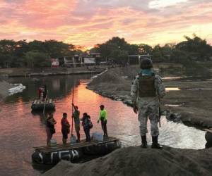 Un miembro de la Guarda Nacional de México mira mientras residentes cruzan el río Suchiate, cerca de Ciudad Hidalgo, en la frontera con Guatemala. Foto: AP.