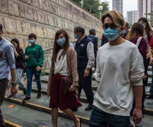 La gente lleva máscaras después de visitar el templo de Wong Tai Sin el primer día del Año Nuevo Lunar de la Rata en Hong Kong. Foto AFP