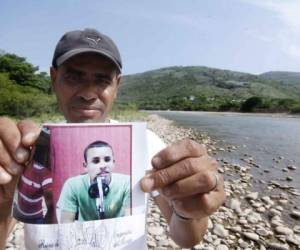 Uno de los familiares del locutor muestra la foto en el lugar donde fue encontrado sin vida.