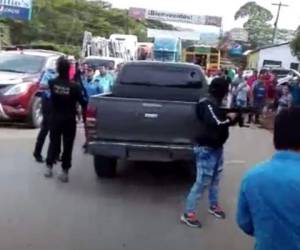 En las imágenes se observa inicialmente cuando una pedrada rompe la ventana trasera del vehículo policial.