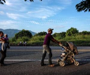 Un migrante hondureño, que participa en una caravana que se dirige a los Estados Unidos, empuja un cochecito en su camino desde San Pedro Tapanatepec a Santiago Niltepec, estado de Oaxaca, México, el 29 de octubre de 2018. - Los cochecitos se han convertido en un artículo de lujo para los migrantes en su viaje, no solo por el número de niños pequeños, sino también porque pueden usarse para llevar sus pertenencias. (Foto de Guillermo Arias / AFP)