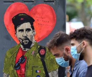 La gente pasa junto a una nueva obra de arte del artista callejero TVBoy que representa al delantero argentino del Barcelona Lionel Messi titulada 'Hasta Siempre Comandante'. Foto: Agencia AFP.