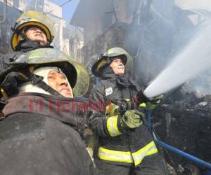 Bomberos tratan de sofocar las llamas en incendio que arrasó con unas seis viviendas en la capital.
