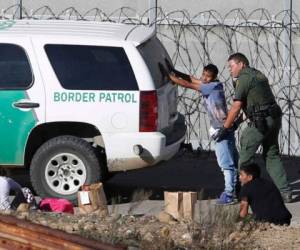 Momento en el que un agente fronterizo de Estados Unidos detiene a un migrante en la frontera. (Foto: Referencia AP)