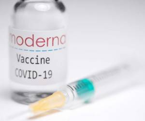 Esta imagen creativa tomada en un estudio en París el 16 de noviembre de 2020, que muestra una jeringa y un frasco de vacuna con el logo reproducido de una firma de biotecnología estadounidense Moderna. Foto: Agencia AFP.