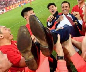 Los jugadores del Guangzhou Evergrande levantan a su entrenador principal Fabio Cannavaro para celebrar después de derrotar al Shanghai Shenhua. Foto AFP
