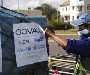 Un operario aeroportuario desinfecta un cargamento de vacunas enviado por el programa COVAX de la ONU. Foto AP